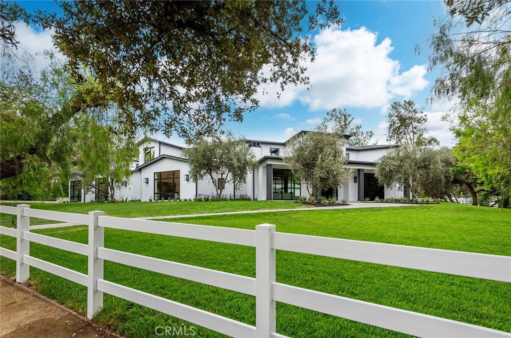 a view of a big house with a big yard and large trees