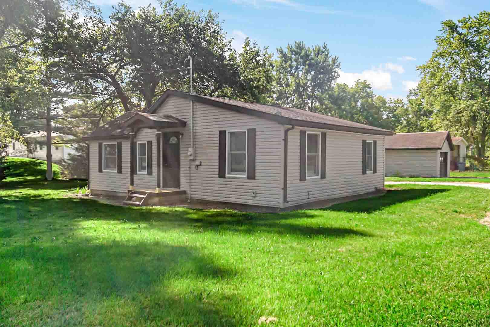 a view of a house with a backyard and a tree