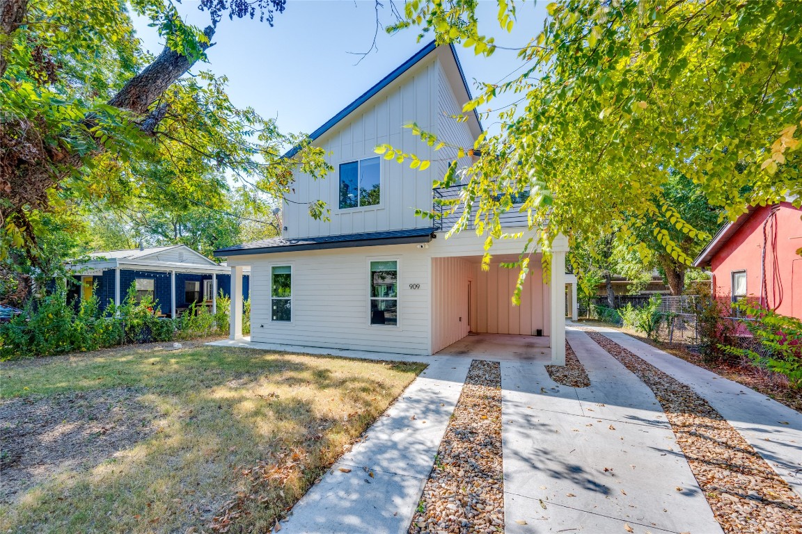 a front view of a house with a yard and trees