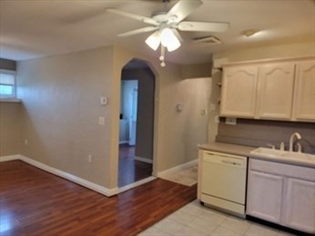 a view of a kitchen with wooden floor and cabinets