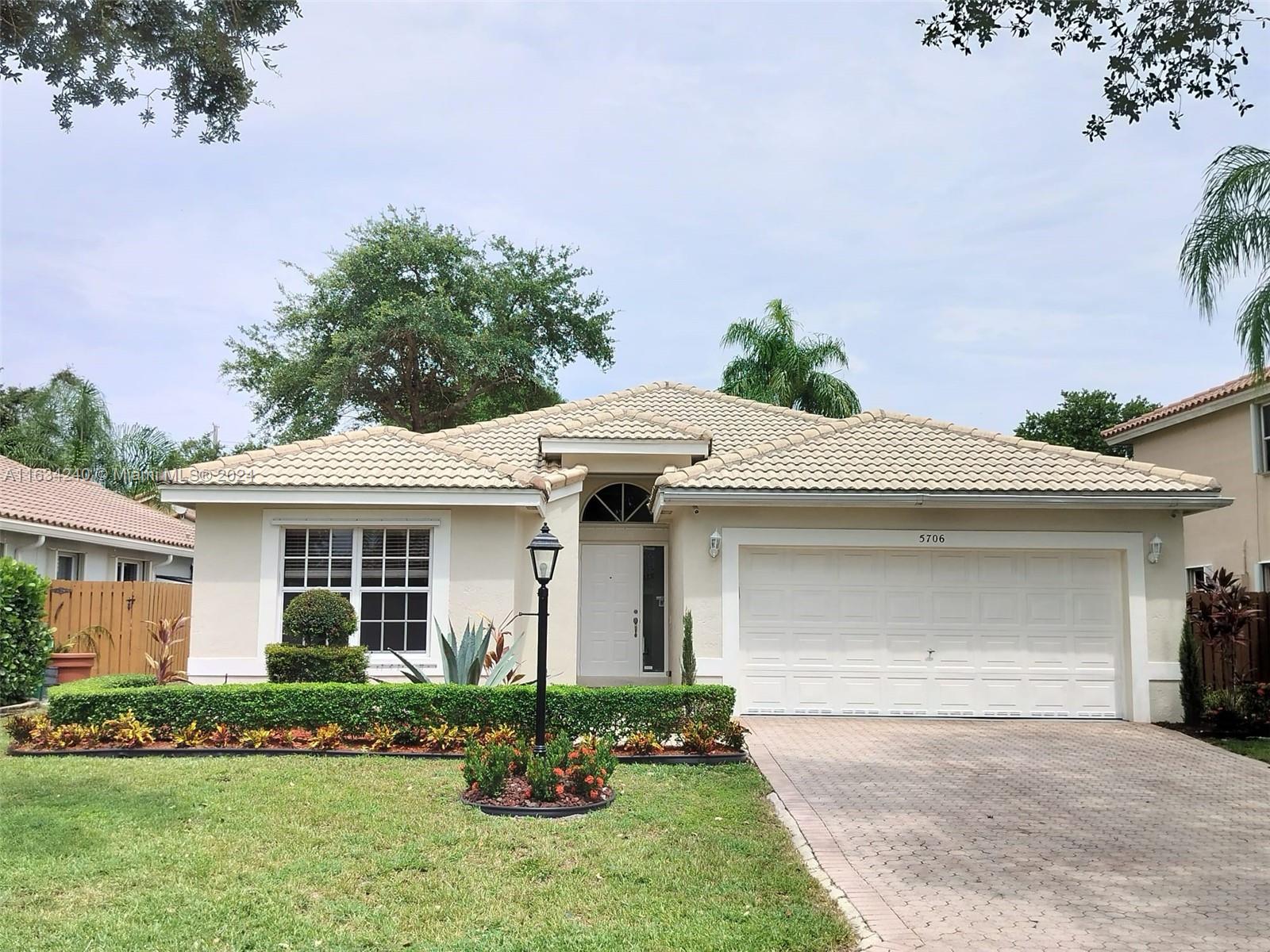 a front view of a house with a garden and yard