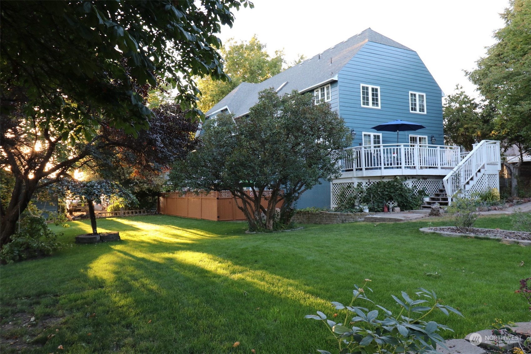 a view of a big house with a big yard and large trees