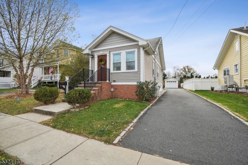 a front view of a house with a yard and potted plants