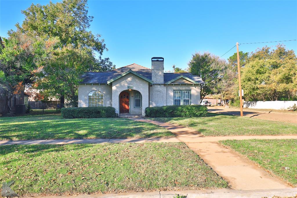 a view of a house with a big yard and large trees