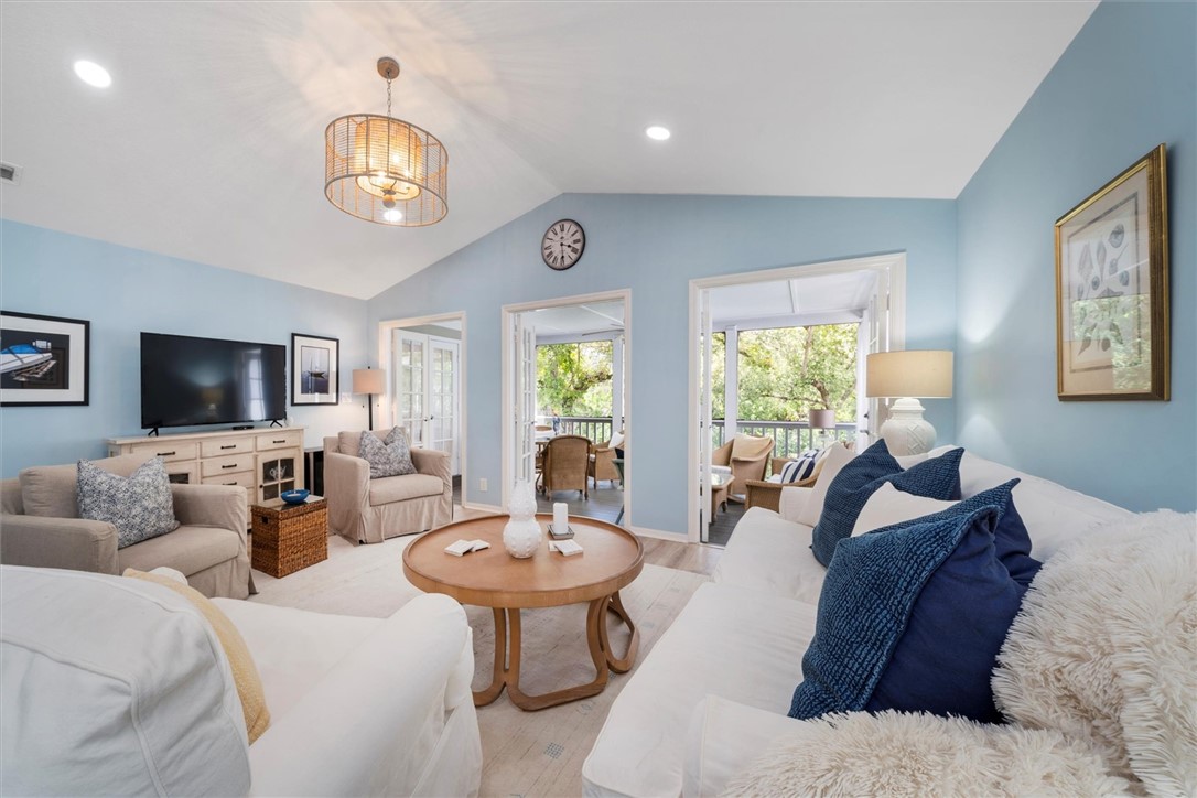 a living room with furniture a flat screen tv and a large window