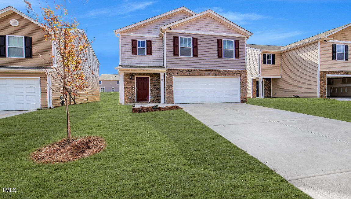 a front view of a house with a yard and garage