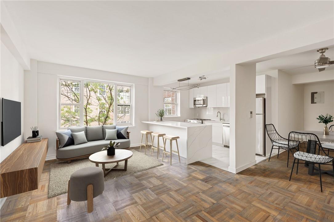 a living room with furniture and a dining table with kitchen view