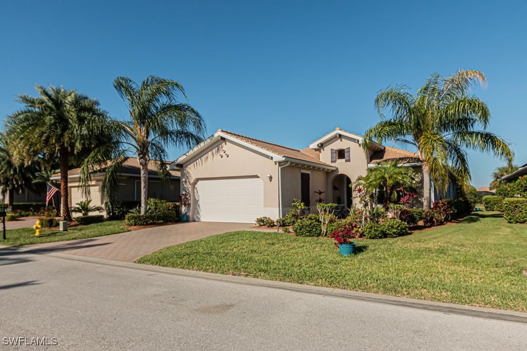 a view of a house with a yard and palm trees