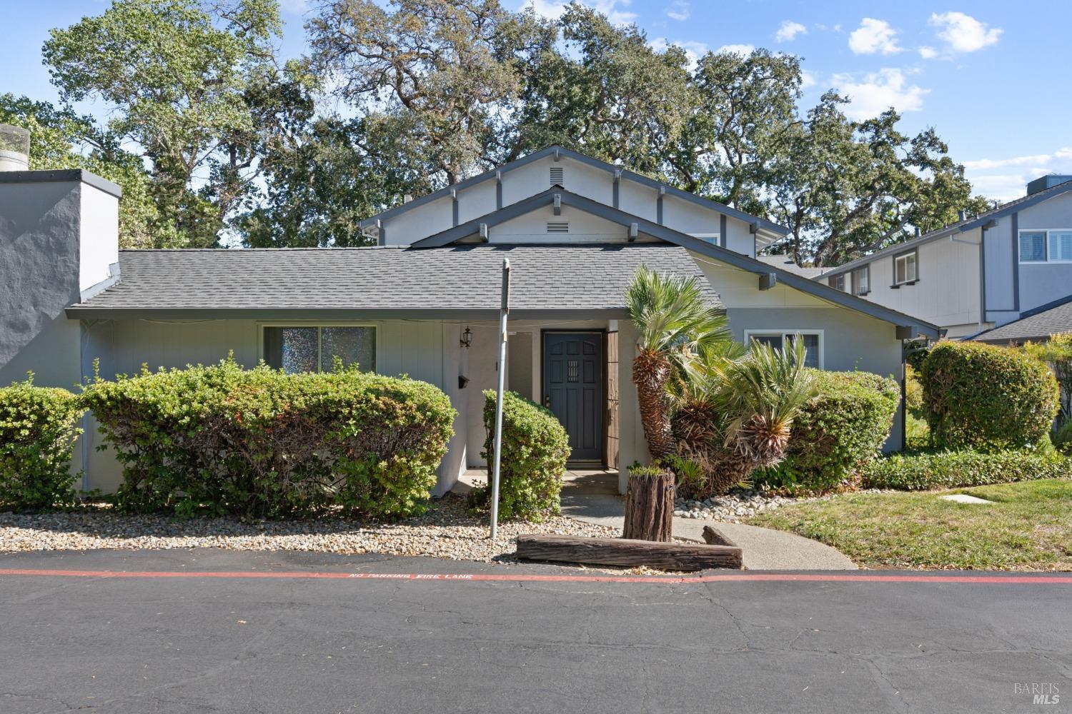 a front view of a house with a yard and potted plants