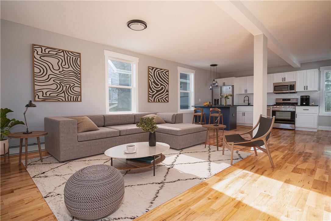 a living room with furniture a rug and kitchen view