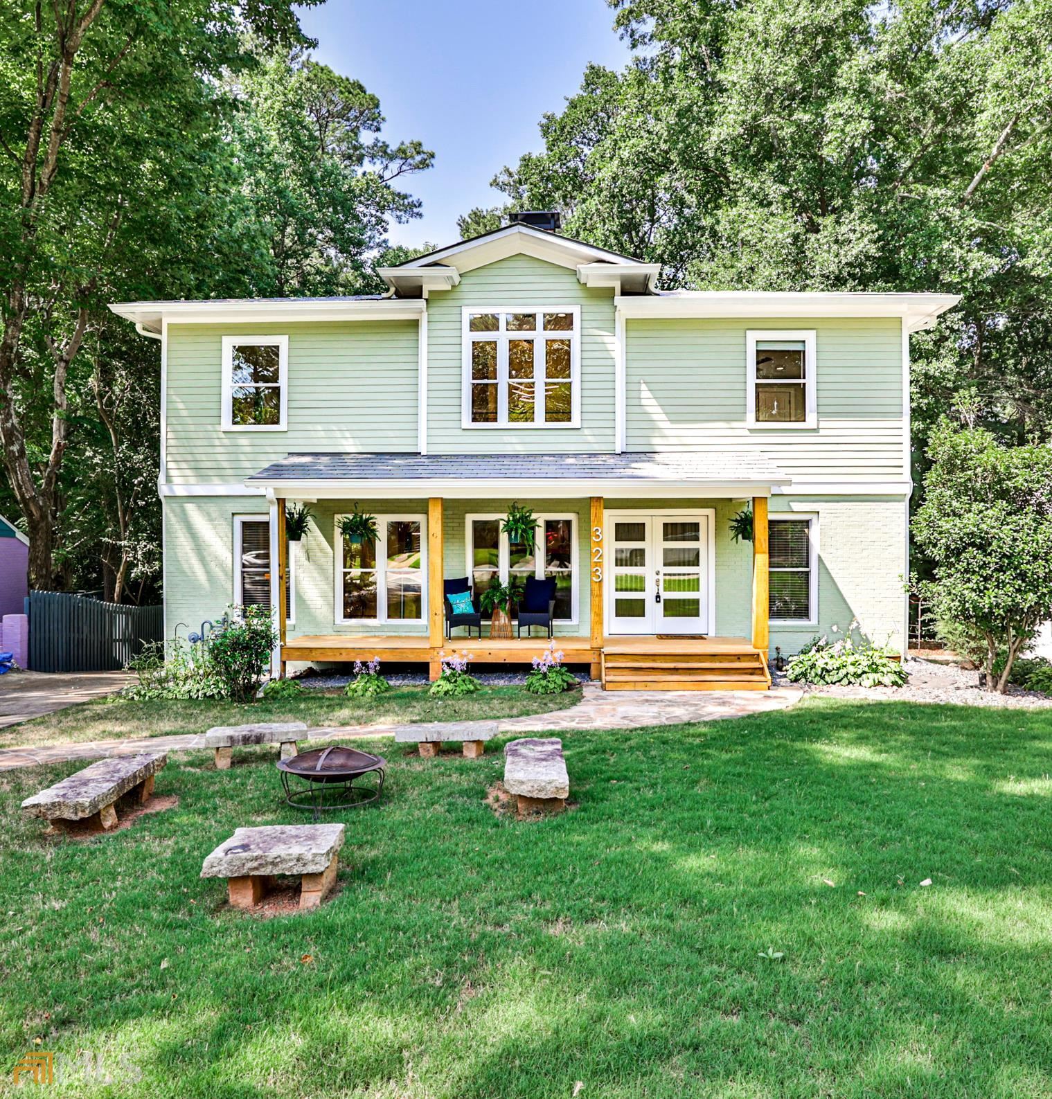 a front view of a house with a yard and trees