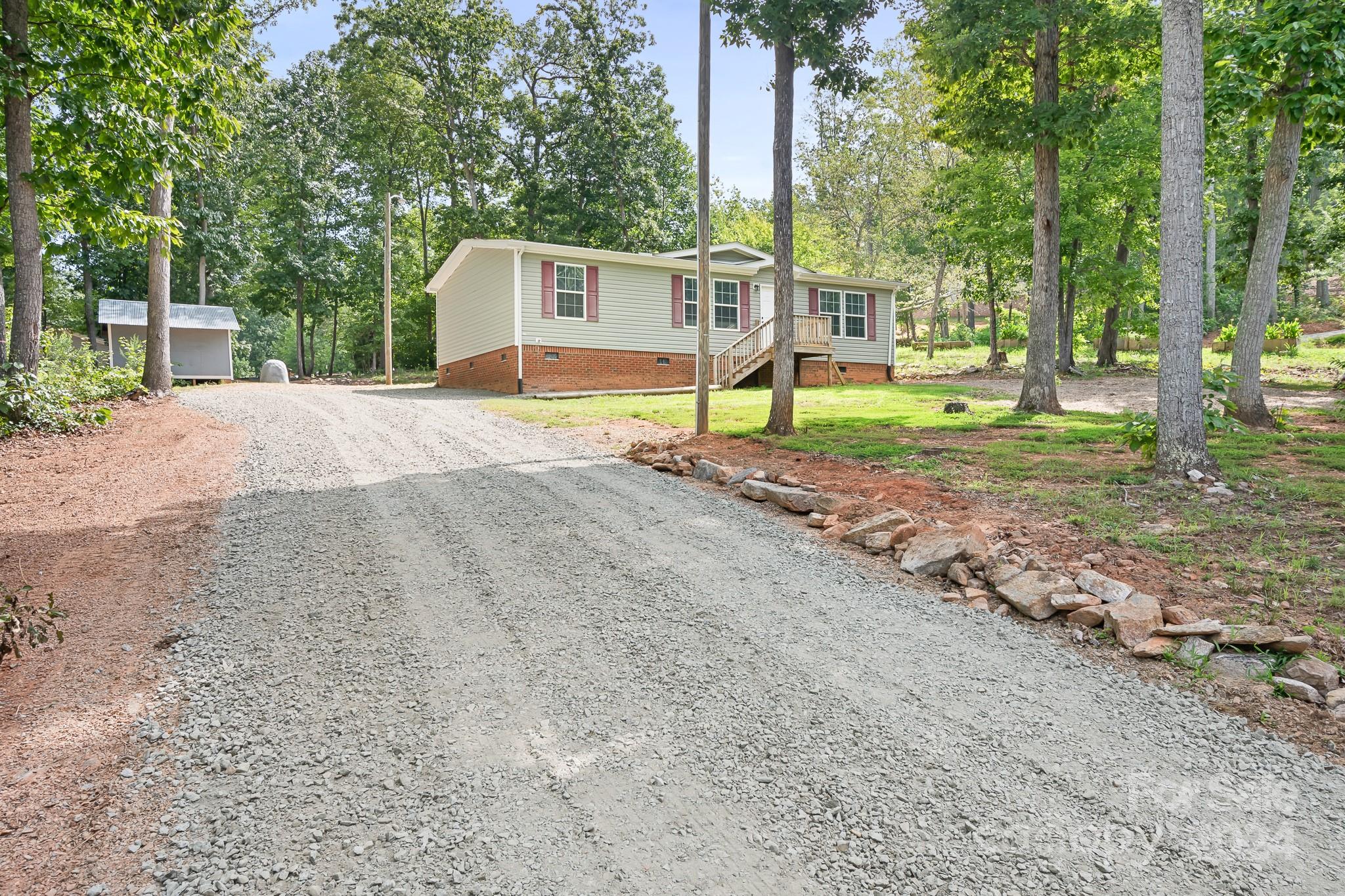 a view of a house with backyard and trees