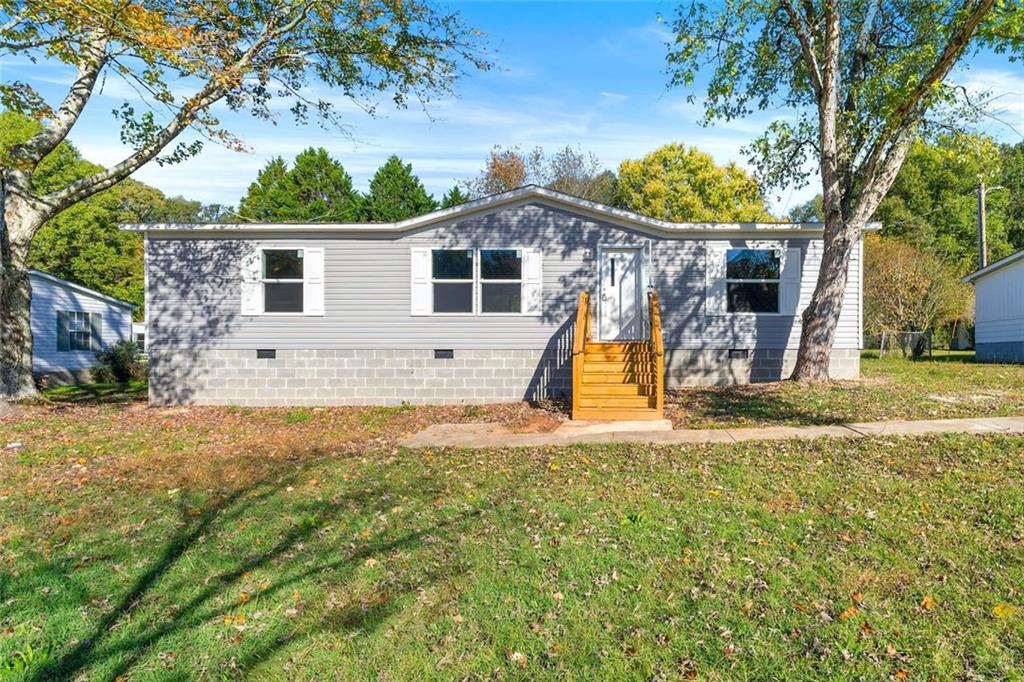 a view of a house with backyard and a tree