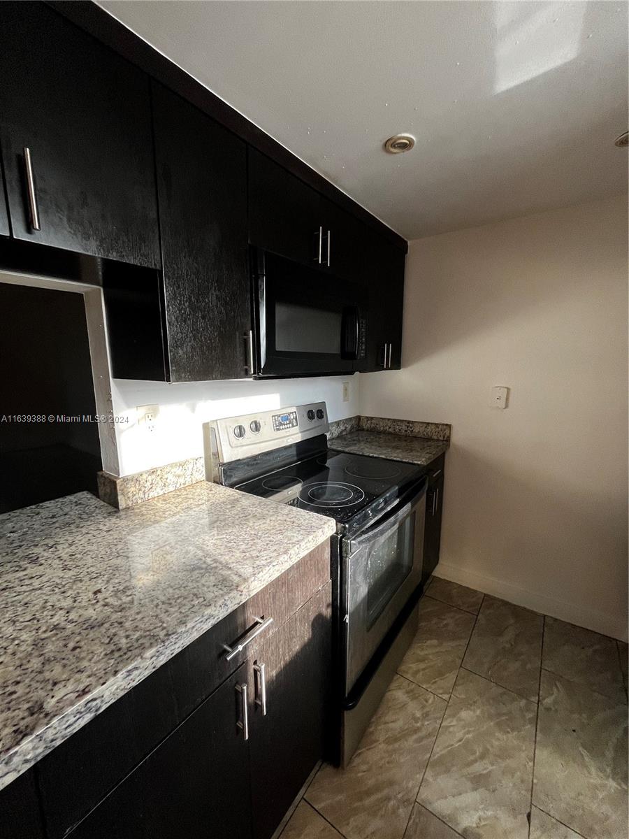 a kitchen with stainless steel appliances granite countertop a sink and a stove