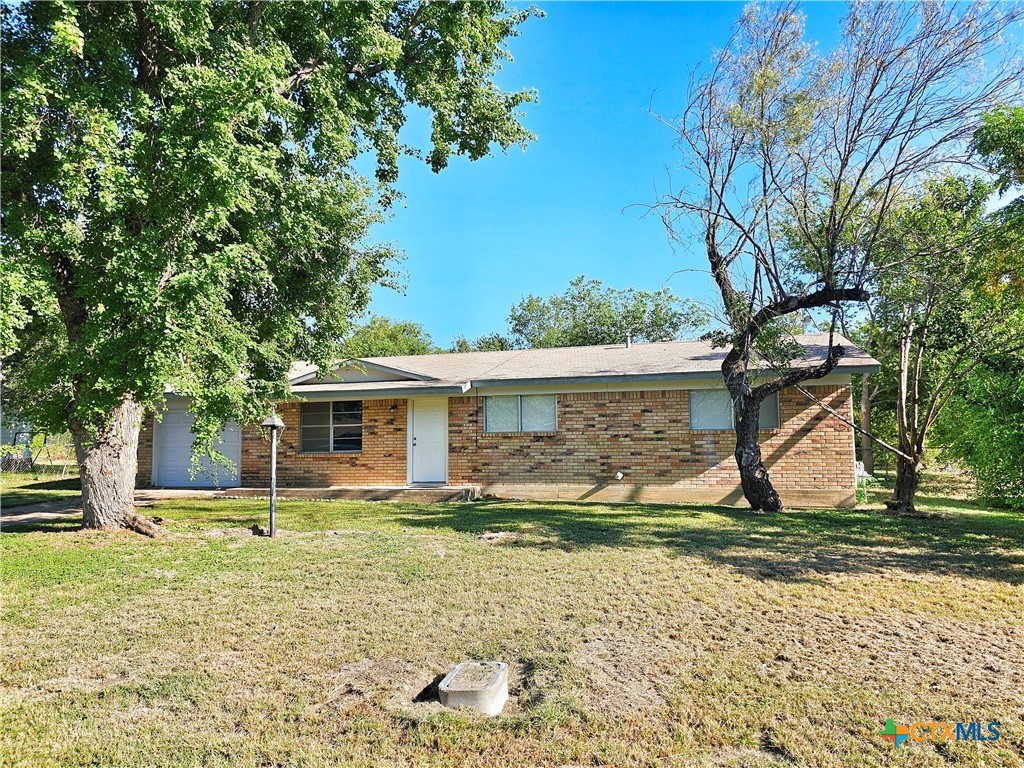 a view of a house with backyard and trees