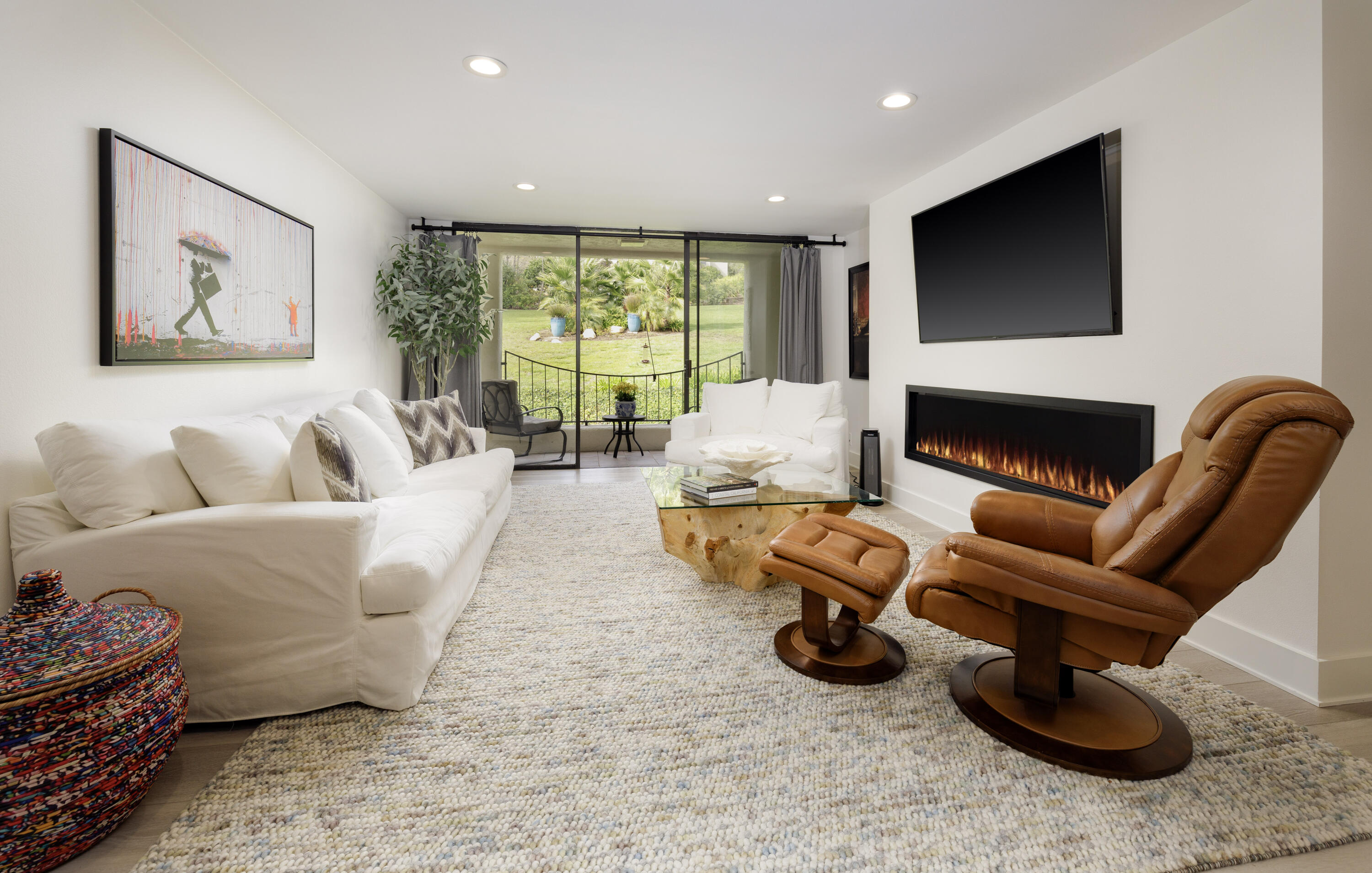 a living room with furniture a flat screen tv and a fireplace