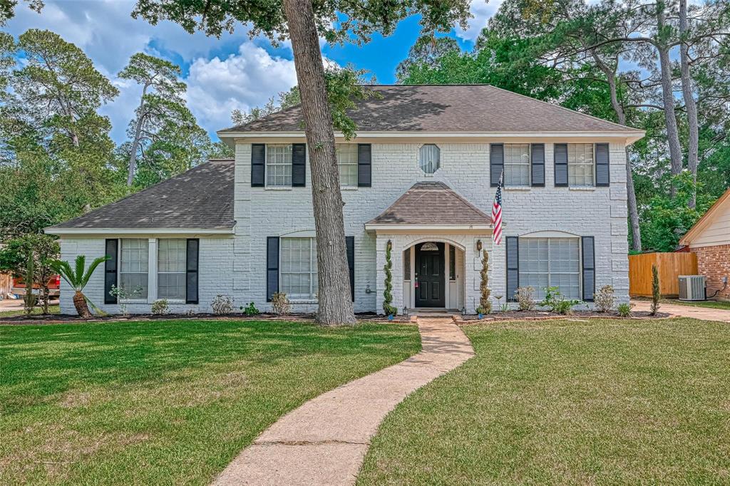 a front view of a house with a yard and trees