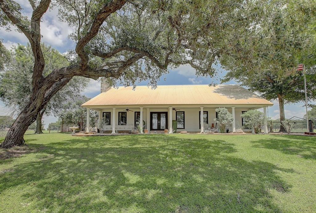 a view of a house with a big yard and large trees