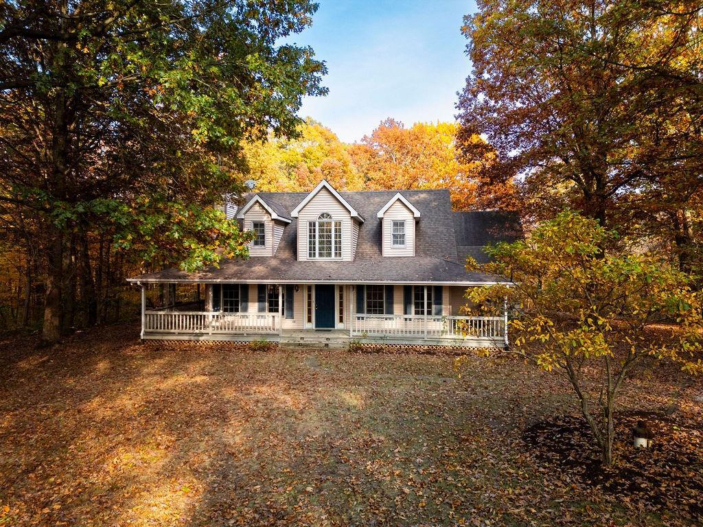 a front view of a house with a yard and trees