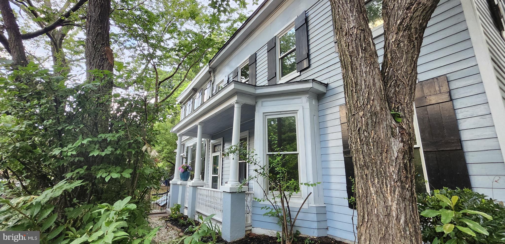 a front view of a house with a tree