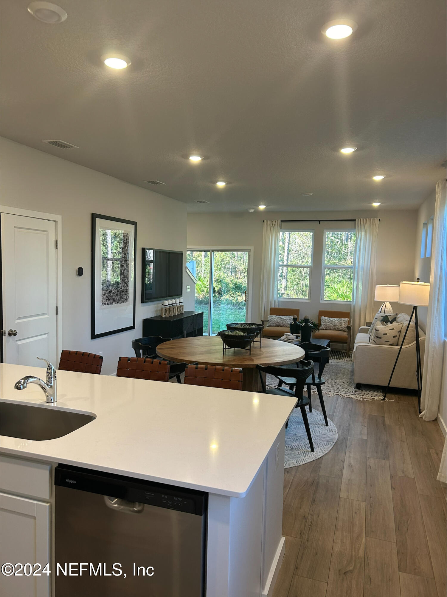 a view of a dining room with furniture a rug and wooden floor