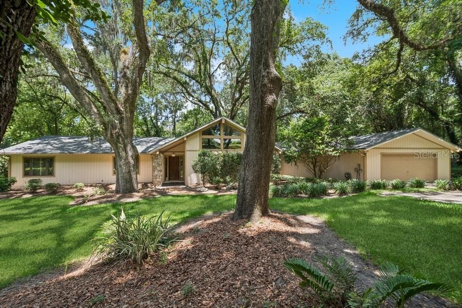 a front view of a house with a yard and trees