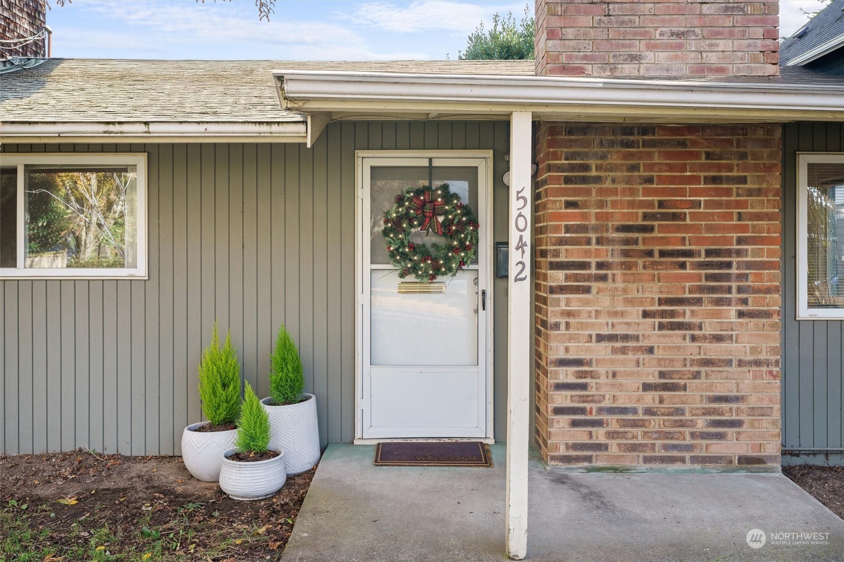 a front view of a house with potted plants