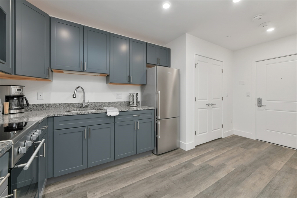 a kitchen with a sink a refrigerator and cabinets