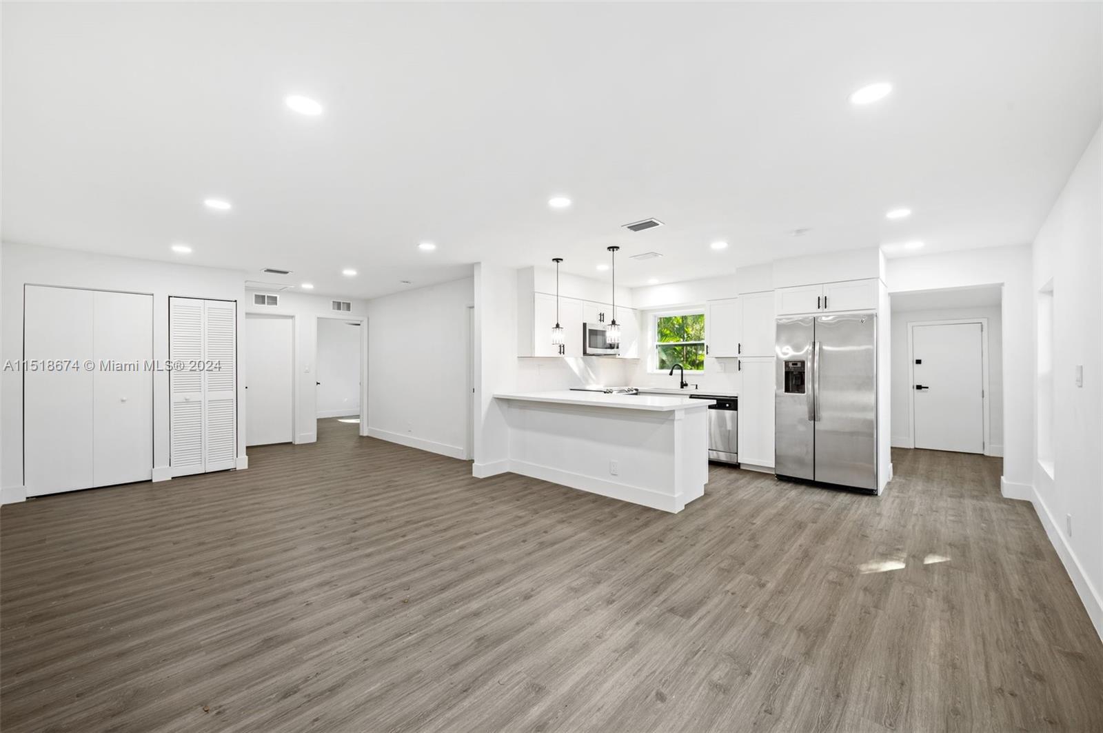 a view of a kitchen with wooden floor and windows