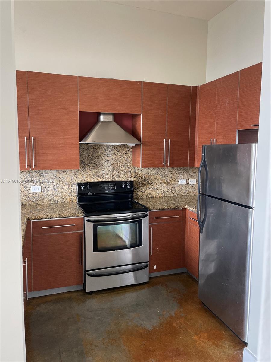 a kitchen with granite countertop stainless steel appliances and wooden cabinets