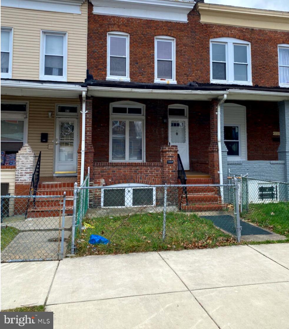 front view of a brick house with a yard