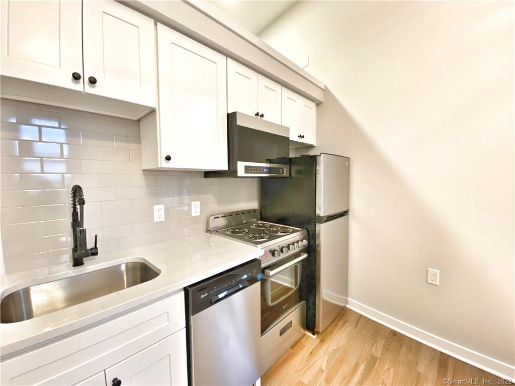 a kitchen with a sink cabinets and a wooden floor