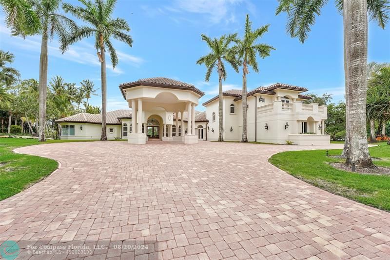 a view of a white house with a yard and palm trees