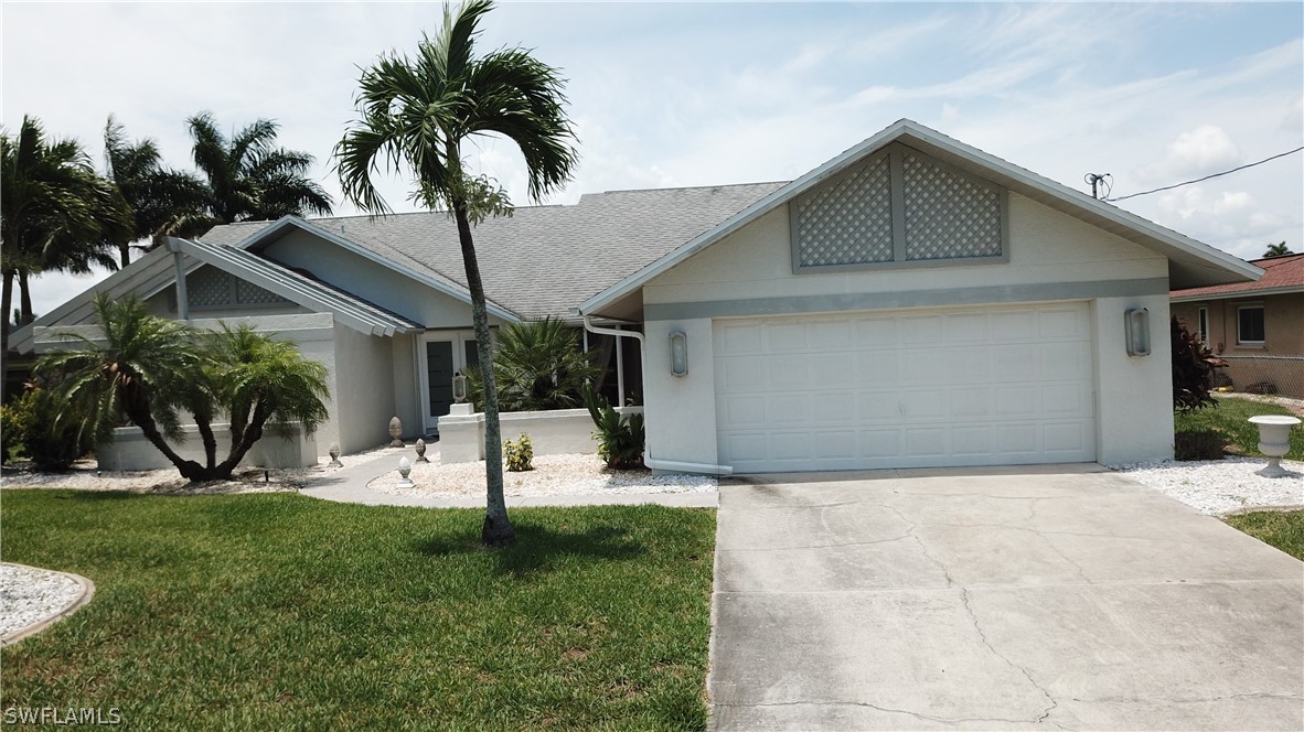 a view of a house with a yard and palm trees