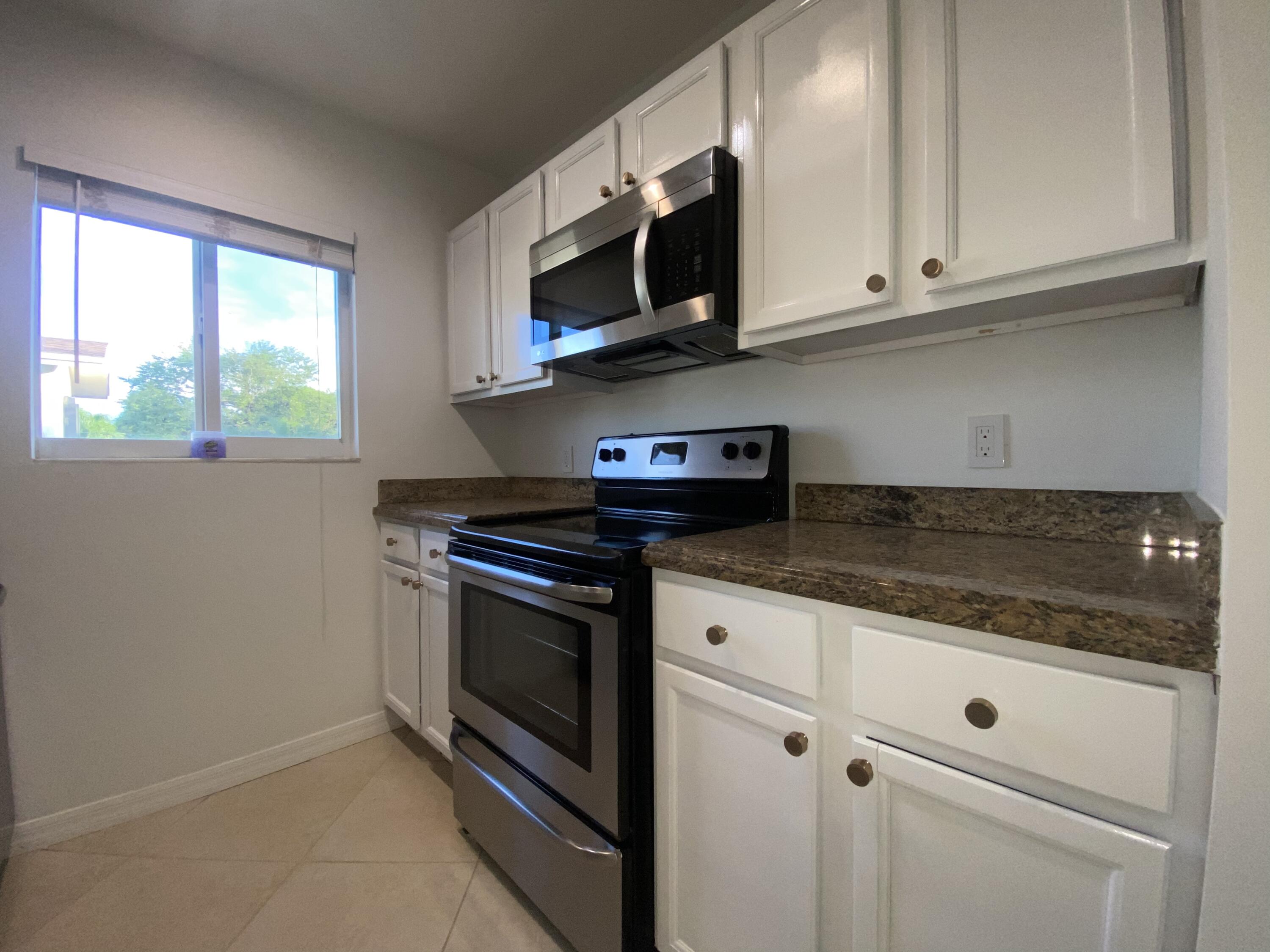 a kitchen with stainless steel appliances granite countertop a stove microwave and sink