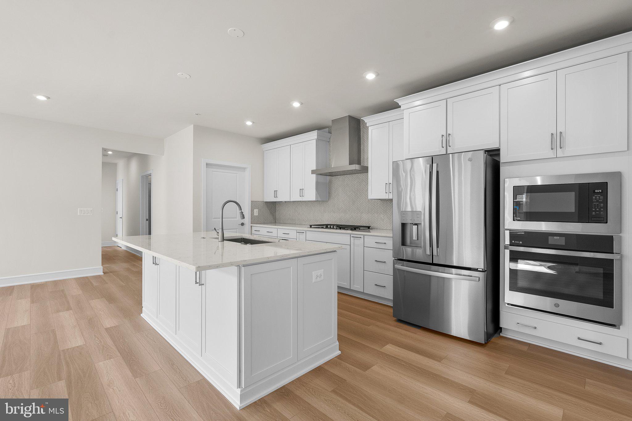 a kitchen with stainless steel appliances a refrigerator sink and microwave