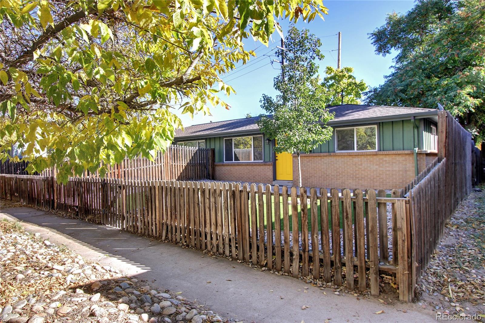 a view of a house with a small yard and wooden fence