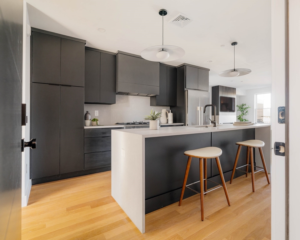 a kitchen with kitchen island a counter top space a sink stainless steel appliances and cabinets