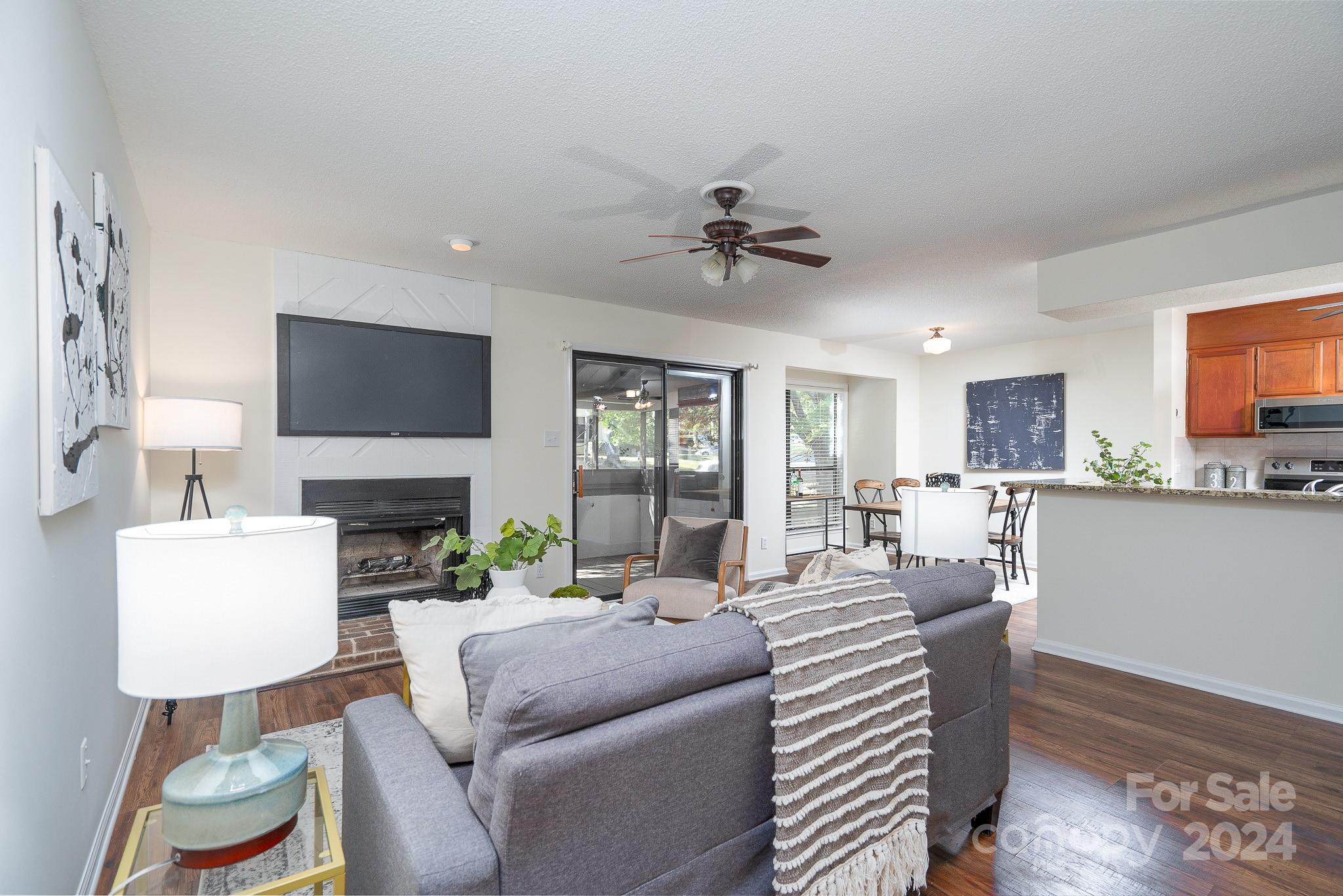 a living room with furniture a fireplace and a flat screen tv