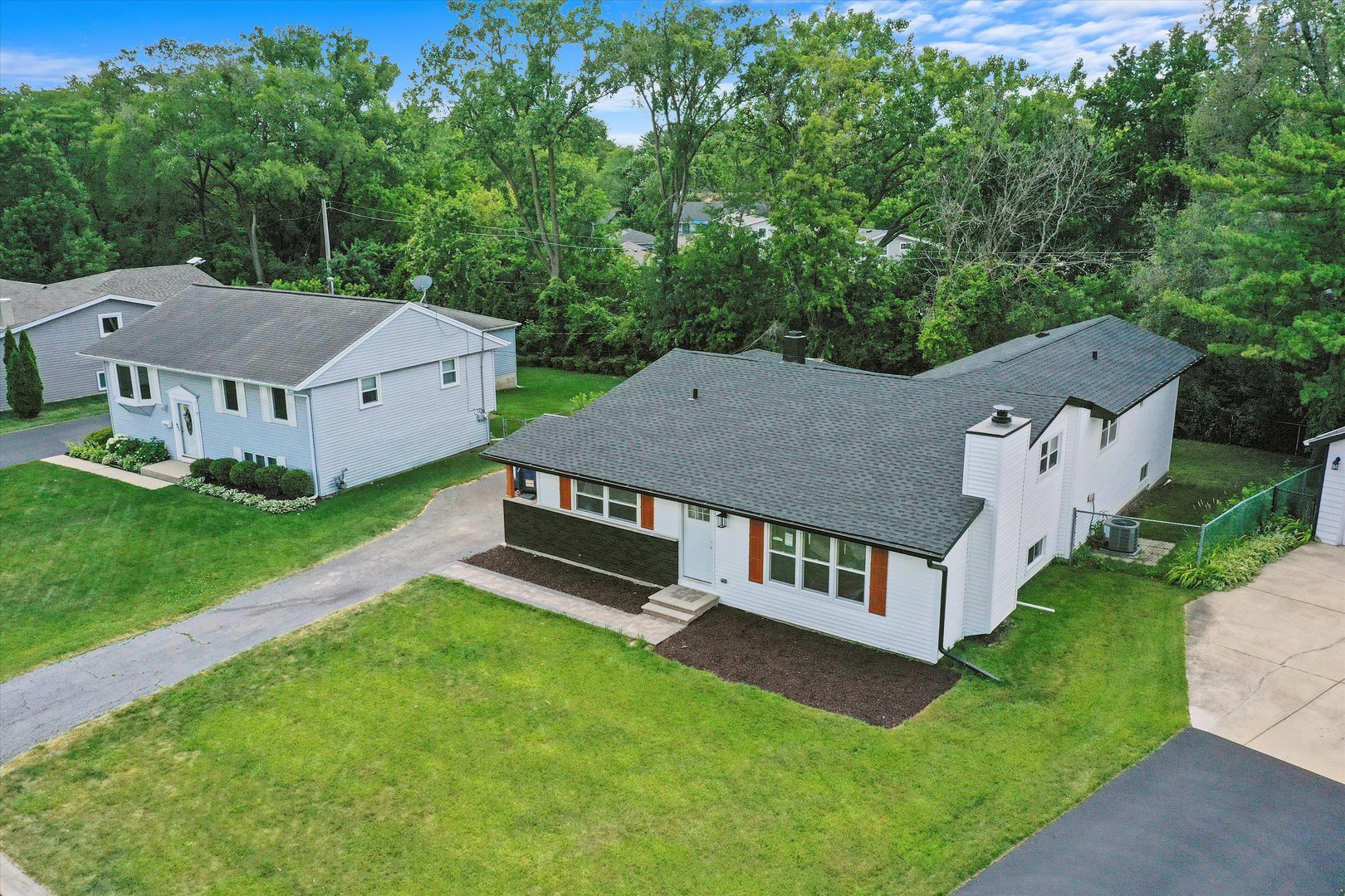 an aerial view of residential house with yard and mountain view in back