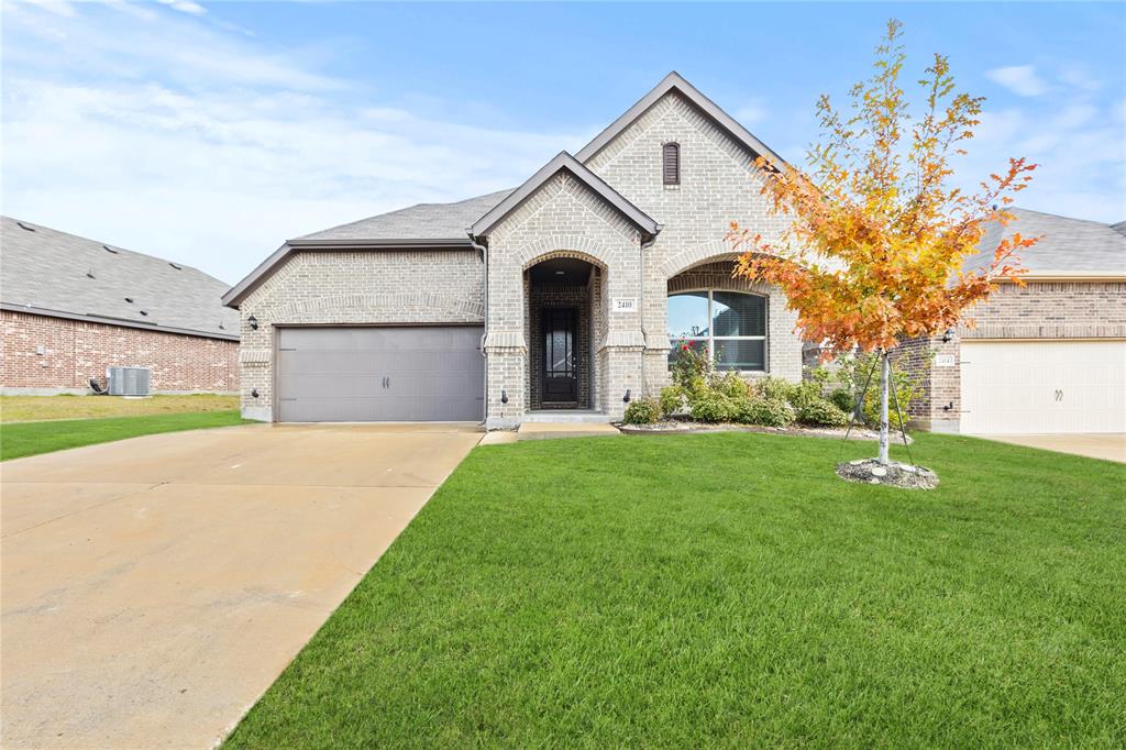 a front view of a house with a yard and garage