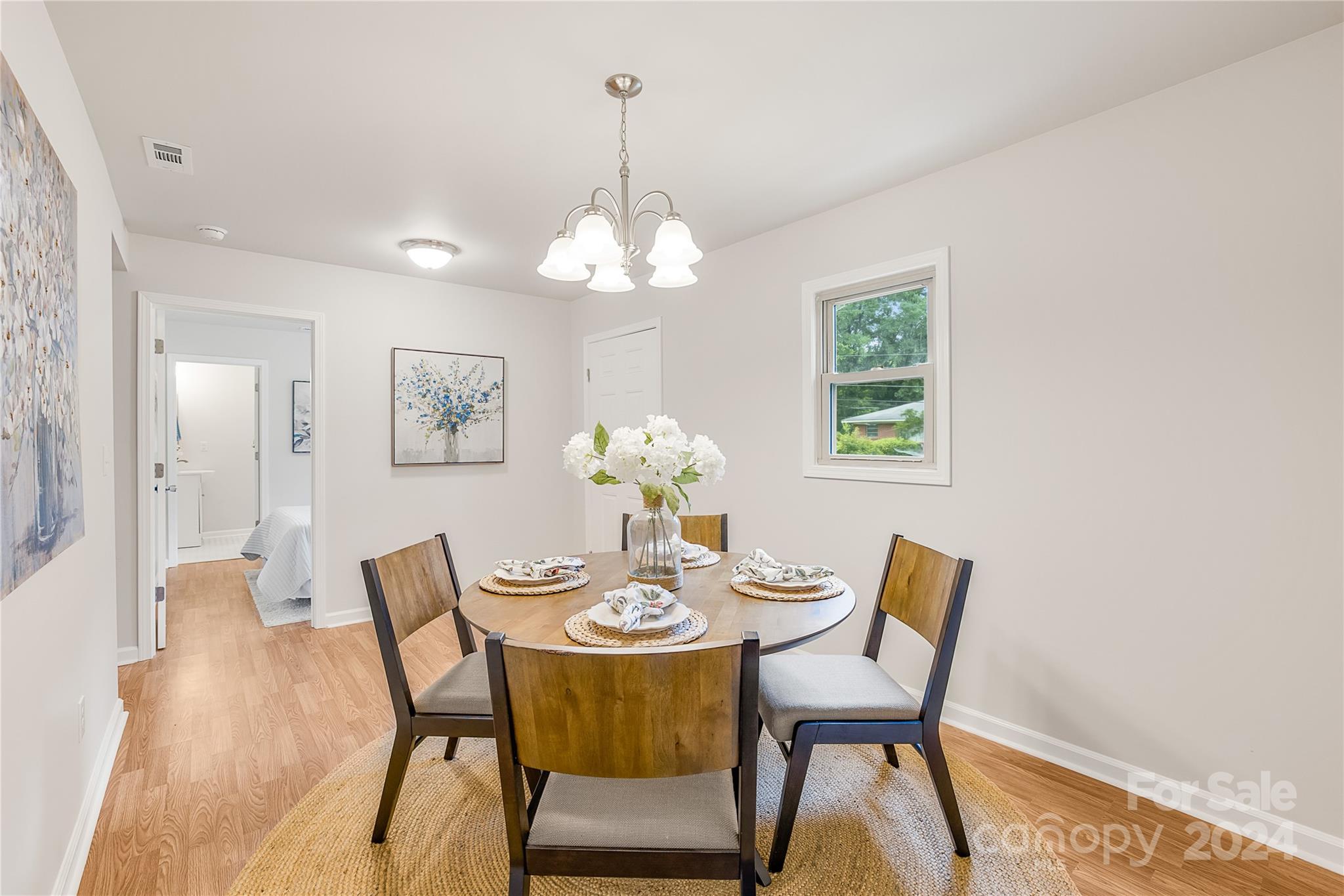 a dining room with furniture a chandelier and wooden floor