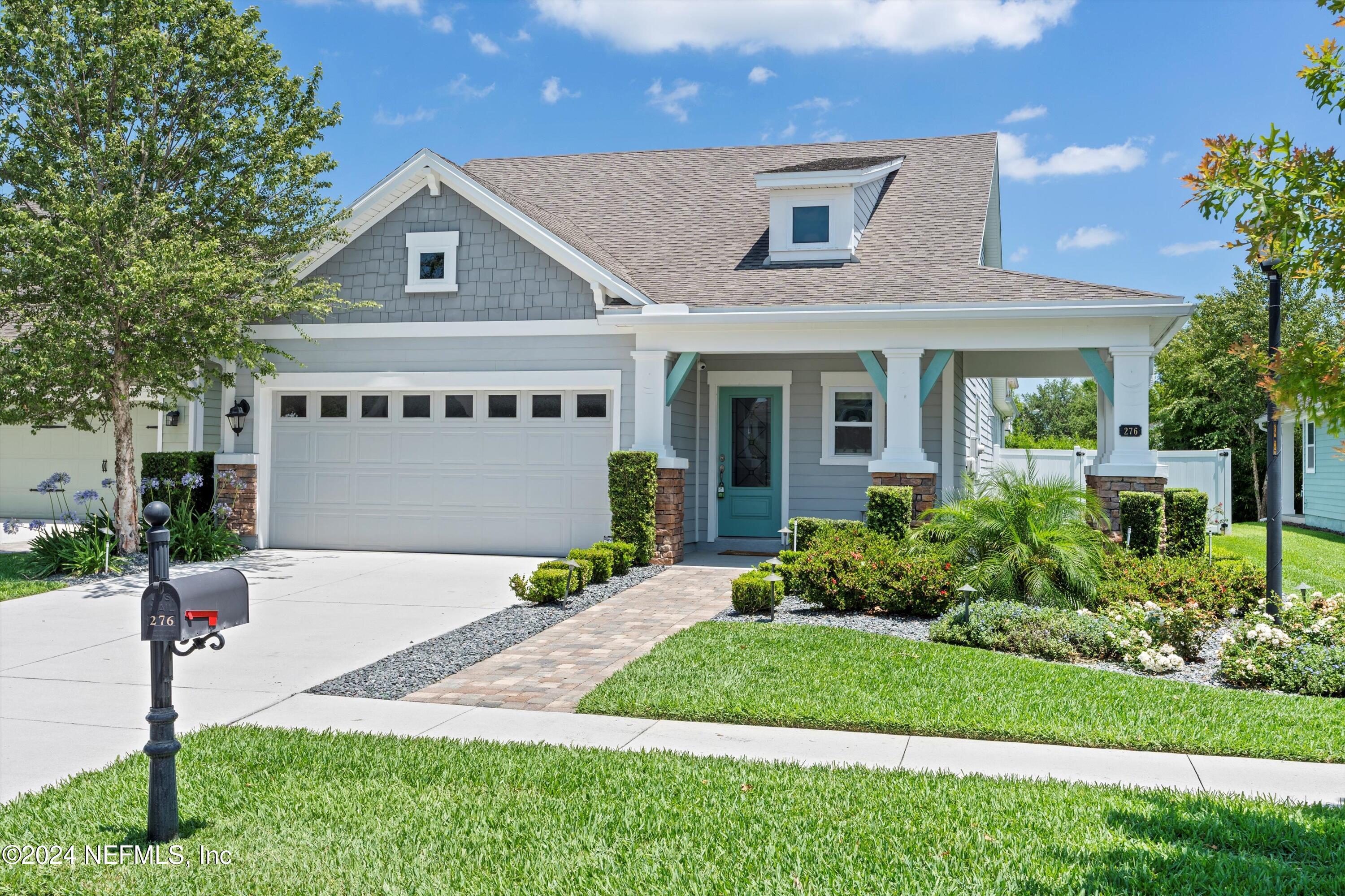 a front view of a house with a garden and plants