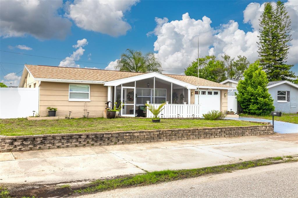 a front view of a house with a yard and potted plants