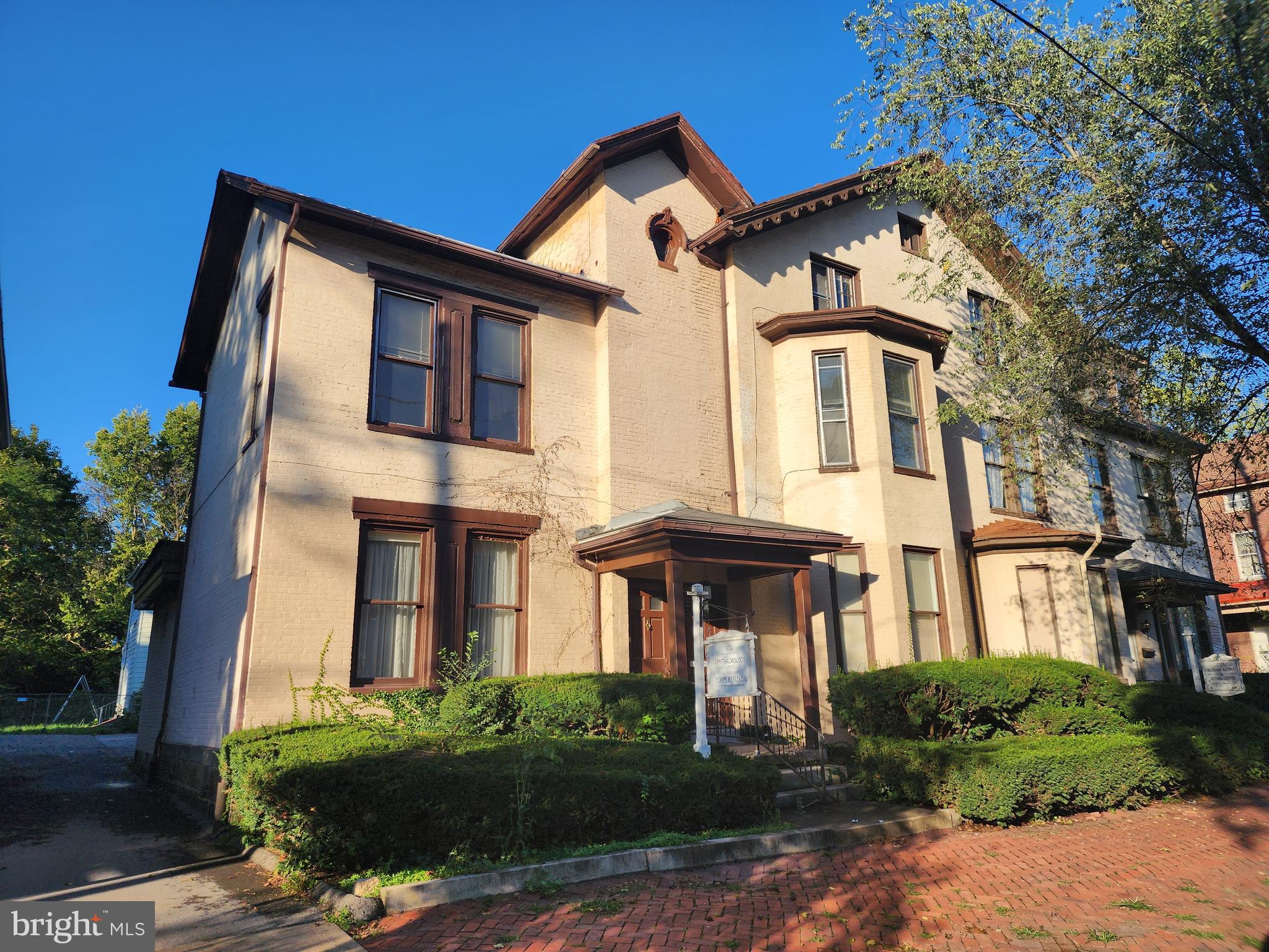 a front view of a house with a garden and plants