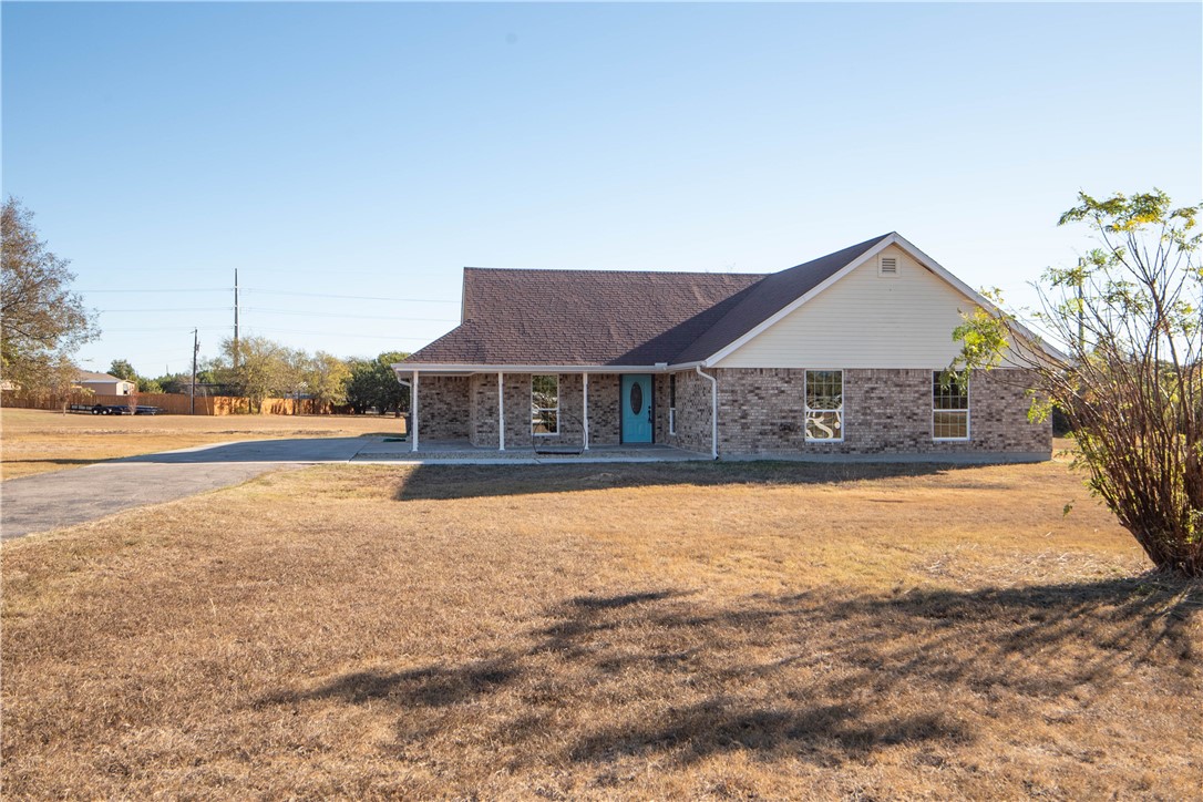 a front view of house with yard and ocean