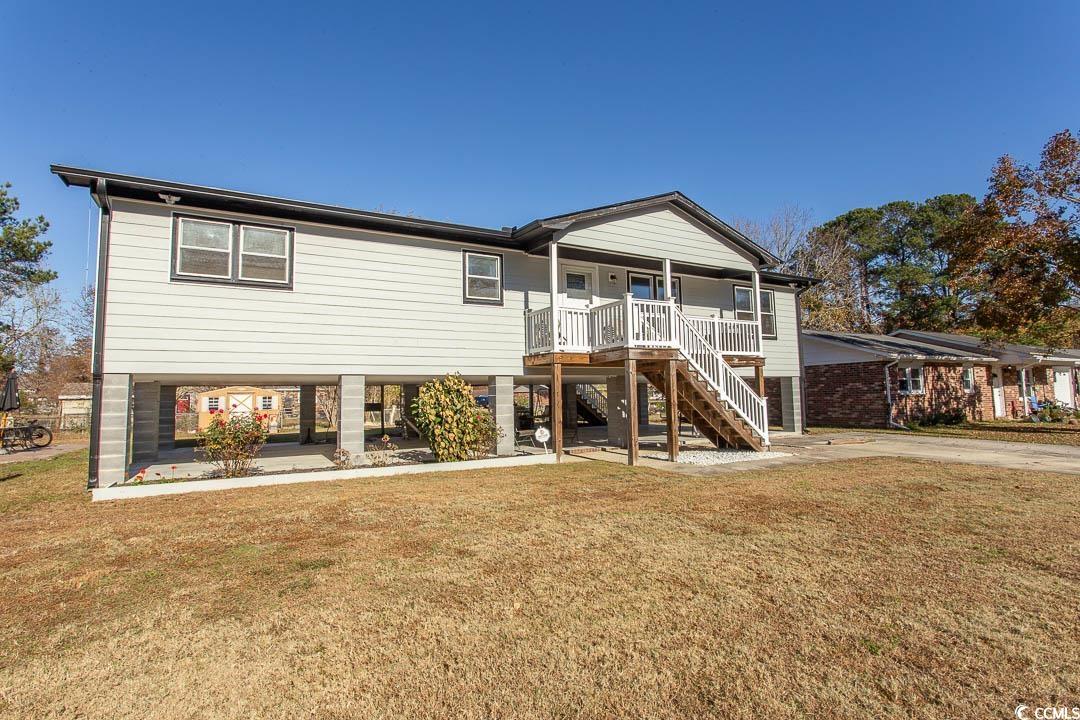 View of front of home with a front lawn and a porc