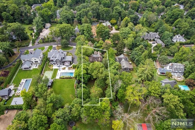 an aerial view of residential house with outdoor space and trees all around