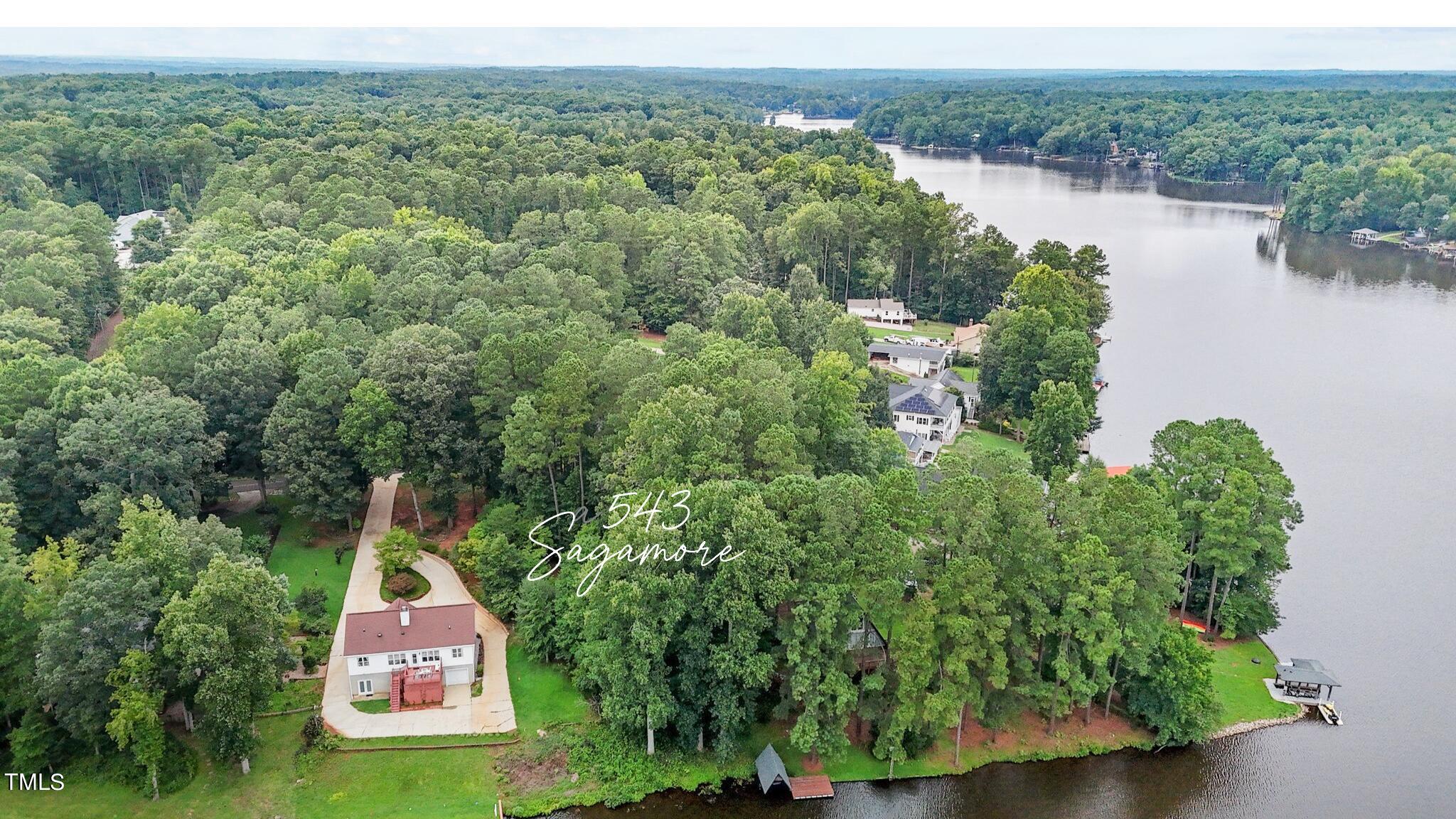 an aerial view of a house with a yard and lake view