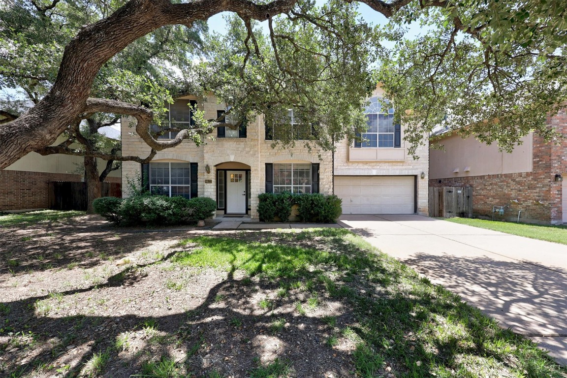 a front view of a house with yard and green space